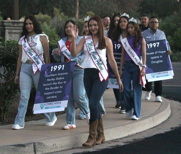 Prior to the vigil a walk took place from the YMCA on Pan American Avenue to the Douglas Police Department. Douglas China Poblana Juliana Padilla, center, carries a sign with a date of remembrance flanked by Bella Noriega, left, and Denise Briseno, right. Bruce Whetten Herald/Review